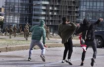 Anti-government protesters throw stones toward Lebanese army soldiers in downtown Beirut, Lebanon, Tuesday, Feb. 11, 2020.