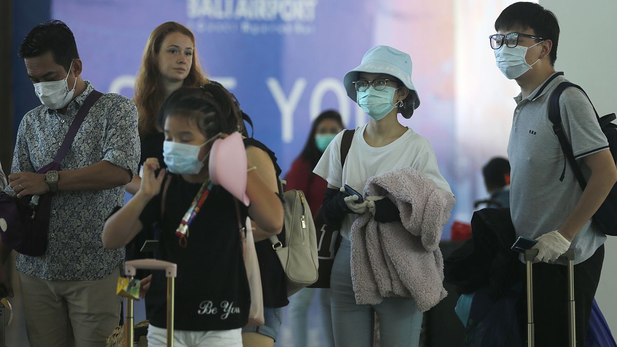 سياح يرتدون أقنعة الوجه في مطار بالي، إندونيسيا  8 فبراير 2020.
