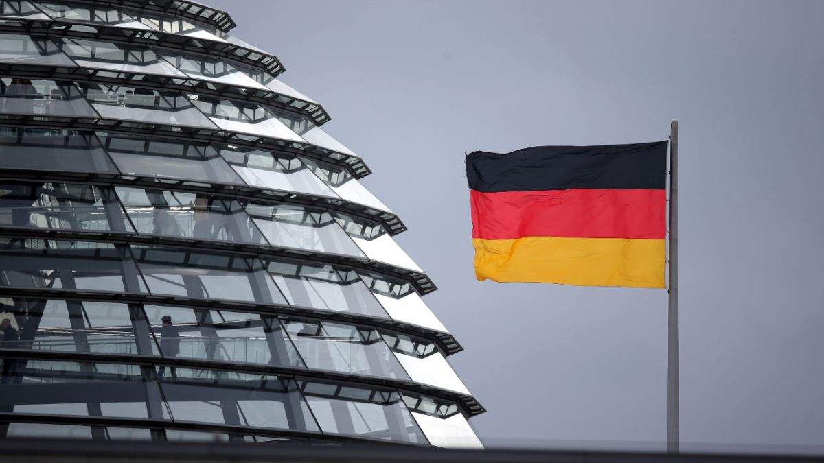 A flag of Germany waves next to the dome of the Reichstag building where the German federal parliament Bundestag meets, in Berlin, Germany, Wednesday, Feb. 12, 2020.