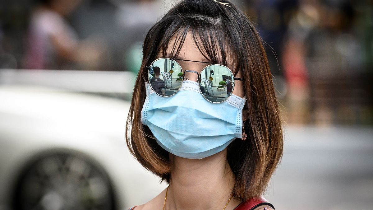 سيدة تضع كمامة على وجهها للوقاية من فيروس كورونا في شوارع بانكوك في تايلاند. 13/02/2020
