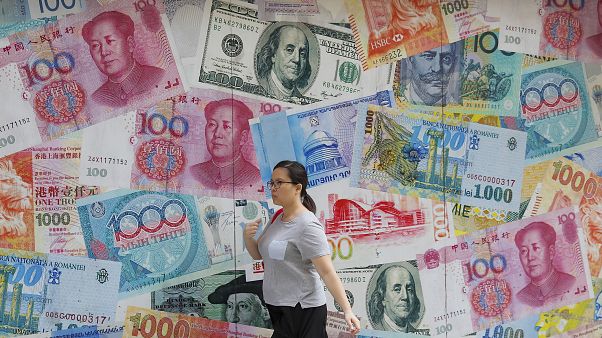 إمرأة تسيرة أمام مصرف للعملات في مركز الأعمال في هونغ كونغ بالصين. 06/08/2019 إمرأة تسيرة أمام مصرف للعملات في مركز الأعمال في هونغ كونغ بالصين. 06/08/2019
