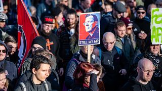 Demonstrators hold a poster showing former Thuringian state premier Bodo Ramelow and reading "Still my MP" at a protest themed "Not with us! No pacts with fascists"