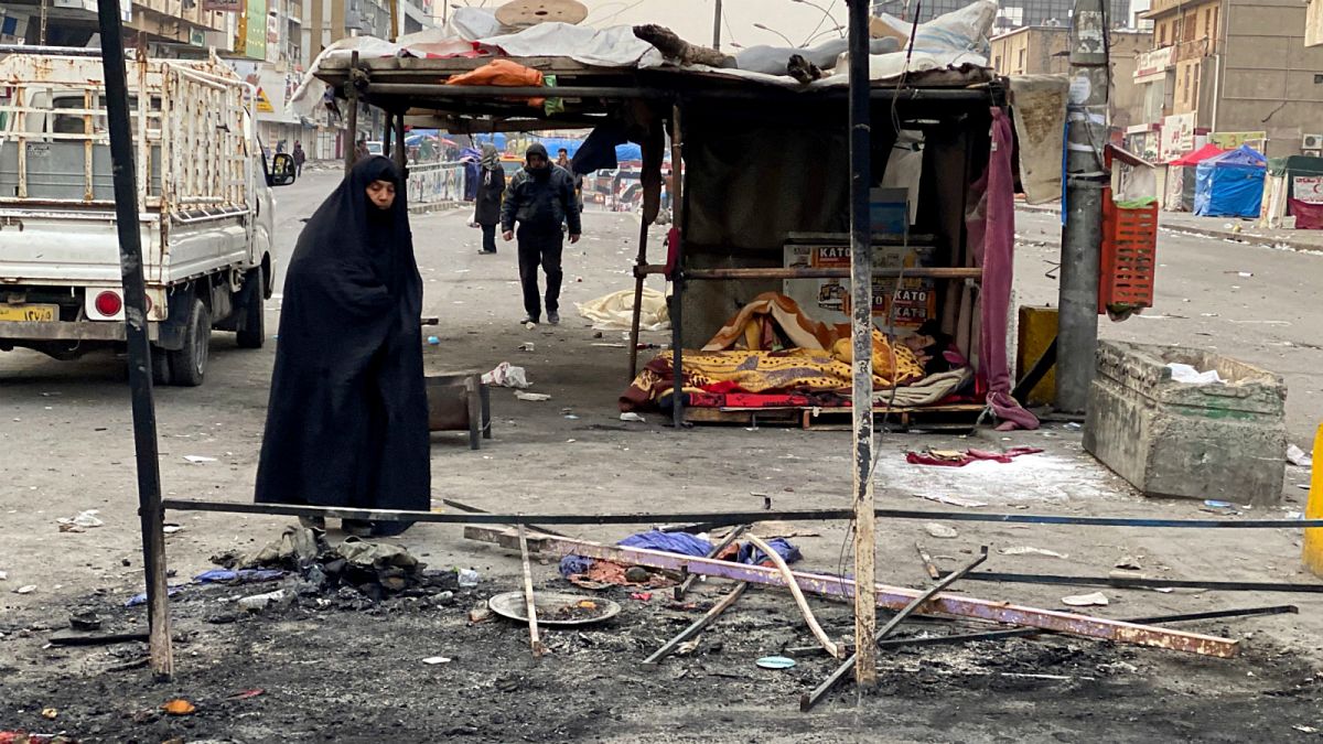 عراقية تتفقد بقايا الخيام وسط بغداد 