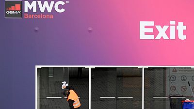 Un trabajador limpia las puertas de cristal en la sede del Congreso Mundial Móvil del CMM el 12 de febrero de 2020 en el centro Montjuic de Fira Barcelona en Barcelona.