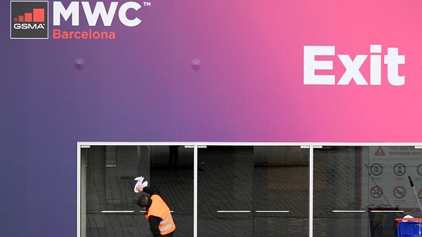 Un trabajador limpia las puertas de cristal en la sede del Congreso Mundial Móvil del CMM el 12 de febrero de 2020 en el centro Montjuic de Fira Barcelona en Barcelona. Un trabajador limpia las puertas de cristal en la sede del Congreso Mundial Móvil del CMM el 12 de febrero de 2020 en el centro Montjuic de Fira Barcelona en Barcelona.