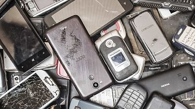 In this photo taken on July 13, 2018, old mobile phones fill a bin at the Out Of Use company warehouse in Beringen, Belgium