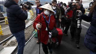 Passengers begin being taken off the quarantined Diamond Princess cruise ship Wednesday, Feb. 19, 2020, in Yokohama, near Tokyo. (AP Photo/Jae C. Hong)