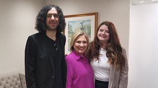 Hillary Clinton with Emma DeSouza and her husband, Jake