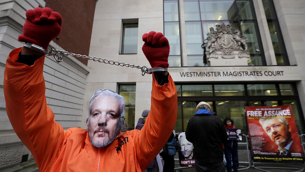 FILE PHOTO: A demonstrator supporting Julian Assange wears a mask and chains outside Westminster Magistrates Court in London, Thursday, Jan. 23, 2020. 