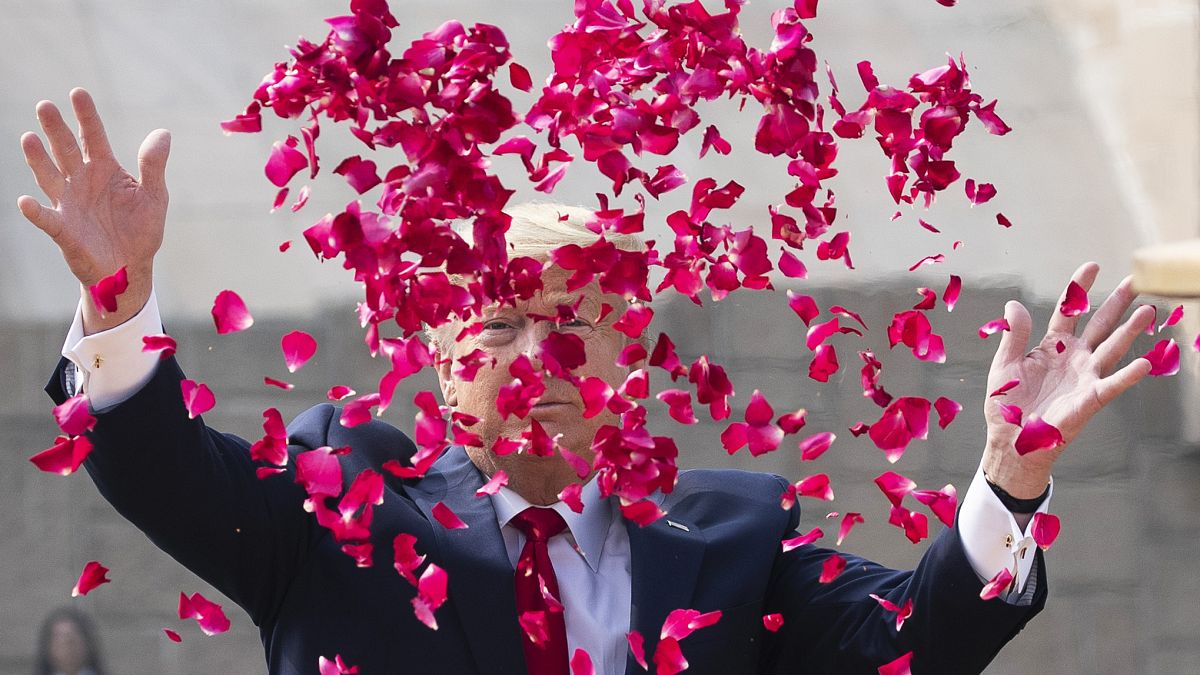 President Donald Trump throws rose petals during a ceremony at the Raj Ghat Mahatma Gandhi Memorial, in New Delhi, India.