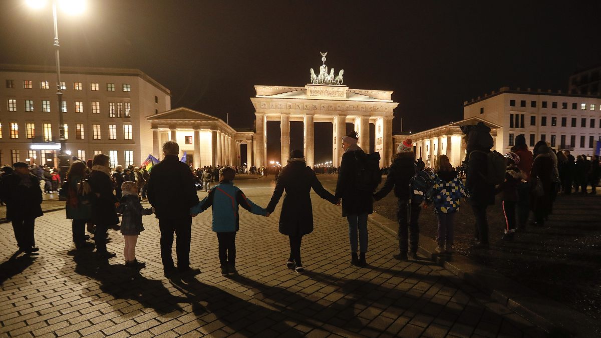 A vigil for victims of last night's shooting in Hanau is held in front of the Brandenburg Gate in Berlin, Germany, Thursday, Feb. 20, 2020. 