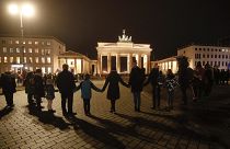 A vigil for victims of last night's shooting in Hanau is held in front of the Brandenburg Gate in Berlin, Germany, Thursday, Feb. 20, 2020. 