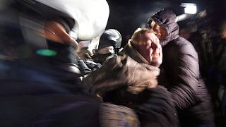 Ukrainian riot police detain a protester, who planned to stop buses carrying passengers evacuated from the Chinese city of Wuhan, outside Novi Sarzhany, Ukraine.