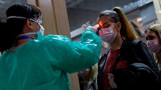 Passengers have their temperature checked at an airport in Hungary