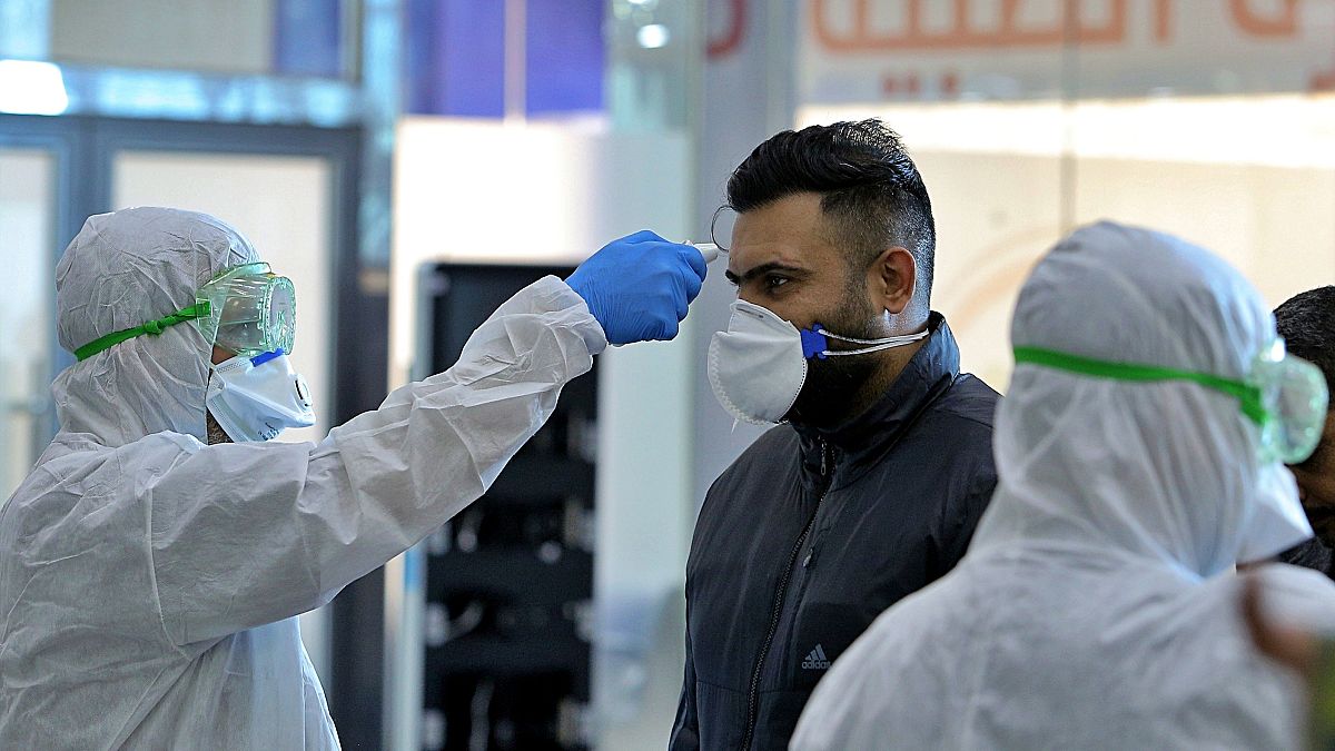 فريق طبي في مطار النجف العراقي يفحص مسافرين وصلوا من إيران، التي وصل منها مسافرون مصابون بالفيروس إلى كل من لبنان وكندا. 