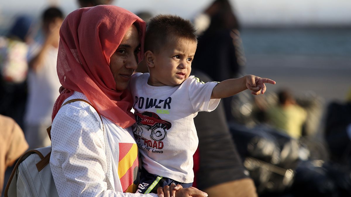 FILE PICTURE - A migrant holds a boy upon their arrival at the port of Thessaloniki, northern Greece, Monday, Sept. 2, 2019. 