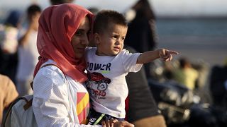 FILE PICTURE - A migrant holds a boy upon their arrival at the port of Thessaloniki, northern Greece, Monday, Sept. 2, 2019. 