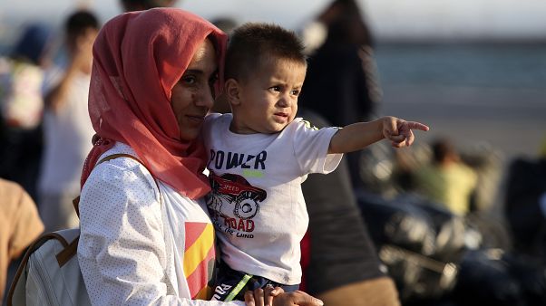 FILE PICTURE - A migrant holds a boy upon their arrival at the port of Thessaloniki, northern Greece, Monday, Sept. 2, 2019. FILE PICTURE - A migrant holds a boy upon their arrival at the port of Thessaloniki, northern Greece, Monday, Sept. 2, 2019.