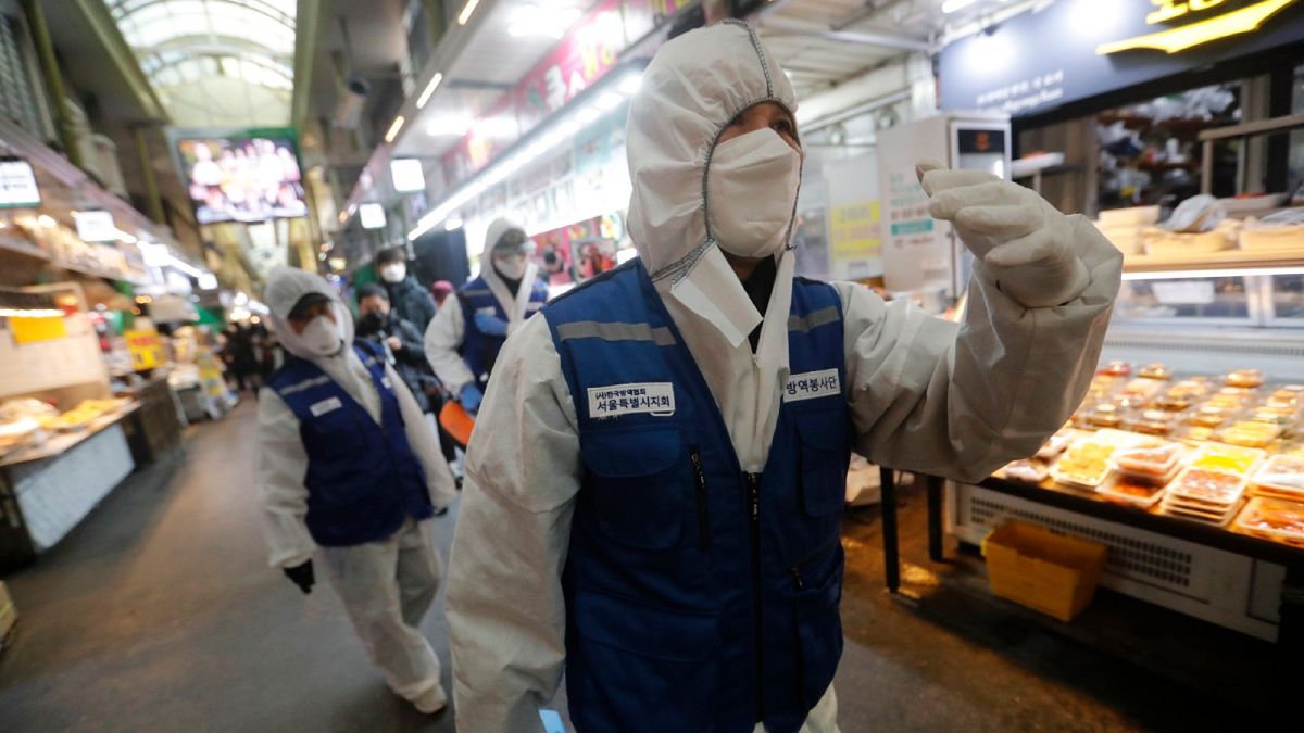 Des agents des services sanitaires dans un marché de Séoul, en,  Corée du Sud, le 24 février 