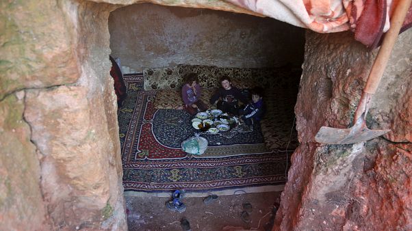 Members of a family of internally displaced Syrians eat together in an underground shelter where several families from Aleppo and Idlib provinces are taking refuge. Members of a family of internally displaced Syrians eat together in an underground shelter where several families from Aleppo and Idlib provinces are taking refuge.