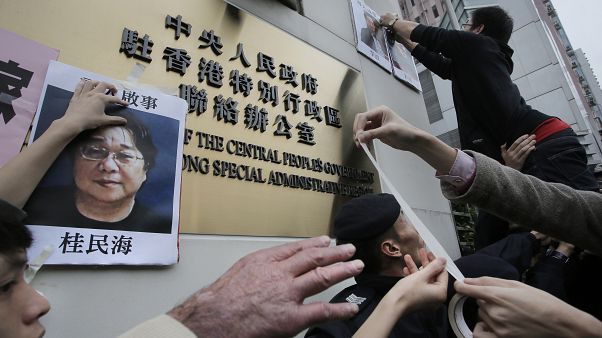 Protesters try to stick photos of missing booksellers, including Gui Minhai (L), outside the Liaison of the Central People's Government in Hong Kong, Jan. 3, 2016. Protesters try to stick photos of missing booksellers, including Gui Minhai (L), outside the Liaison of the Central People's Government in Hong Kong, Jan. 3, 2016.