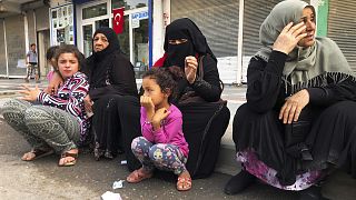 Syrian refugees living in Akcakale, southeastern Turkey, wait for bread distribution by the local municipality