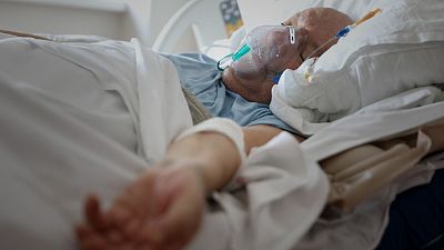 A patient breathes through an oxygen mask in the COVID-19 section of the University Clinical Centre hospital in Banja Luka, Bosnia, Thursday, Nov. 4, 2021.