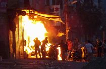 Una tienda arde incendiada por una multitud la incendia durante los violentos disturbios en Nueva Delhi, India.