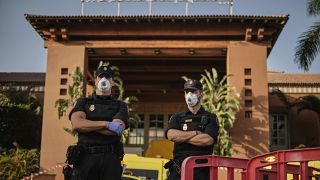 ضباط شرطة يرتدون أقنعة أمام فندق "أتش 10 كوستا أديجي بالاس"، في جزر الكناري بإسبانيا  26/02/2020