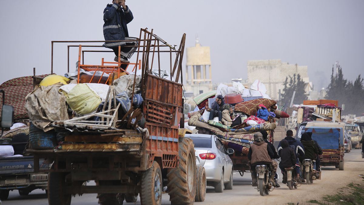 Syrian refugees head northwest through the town of Hazano in Idlib province as the flee renewed fighting Monday, Jan. 27, 2020. 