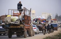 Syrian refugees head northwest through the town of Hazano in Idlib province as the flee renewed fighting Monday, Jan. 27, 2020.