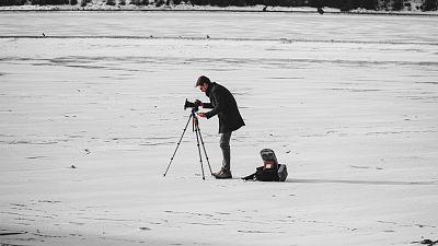 A man filming on a snowy backdrop. A man filming on a snowy backdrop.