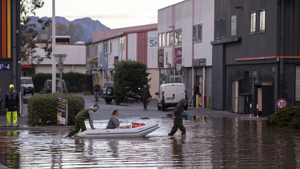 Des habitants traversent une rue inondée avec un canot pneumatique pour inspecter les dégâts dans la ville de Fréjus, en France, lundi 2 décembre 2019. 