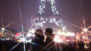 زوجان يتبادلان القبل أمام برج إيفل، خلال احتفالات رأس السنة الجديدة في باريس يوم 2020/01/01.