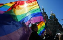 Personne brandissant le drapeau de la communauté LGBT+ sur la Place Rouge à Moscou