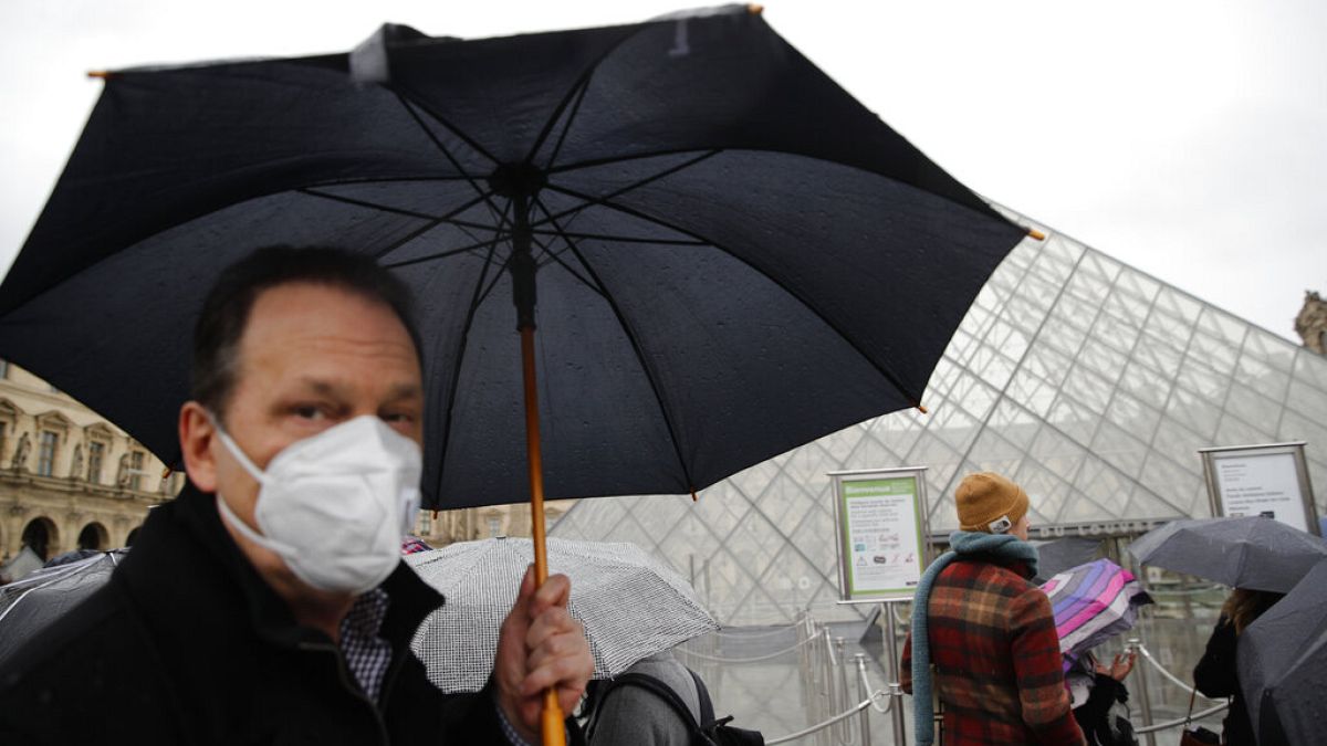 COVID-19 is placing huge demand on masks and gloves, the WHO warned. A tourist wears one outside the Louvre in Paris. 
