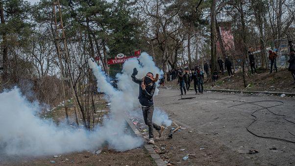 Un migrant renvoie une grenade de gaz lacrymogène à la police grecque à la frontière greco-turque, le 04 mars 2020 Un migrant renvoie une grenade de gaz lacrymogène à la police grecque à la frontière greco-turque, le 04 mars 2020