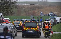 Gendarmes and firefighters gather at the site where a high-speed TGV train locomotive derailed 