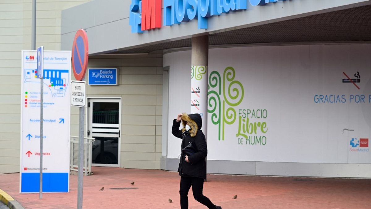 Una mujer con una máscara abandona un hostpital de Madrid