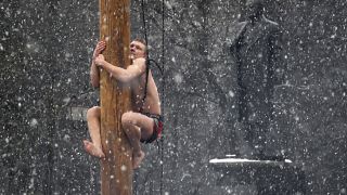 A man climbs on a pole in snowfall to get a prize during celebrations of Maslenitsa, or Pancake Week, in Veliky Novgorod, Russia.