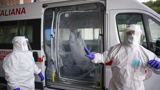 Egy koronavírusos beteg szállítására készülnek az egészségügyi dolgozók Rómában
