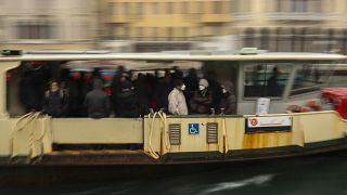 In this March 2, 2020 photo, commuters and locals take a bus boat in Venice, Italy.