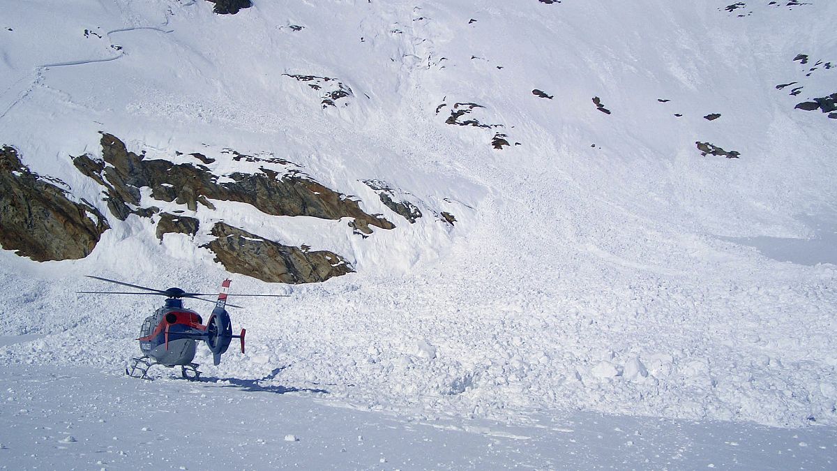 A helicopter is seen following an avalanche 