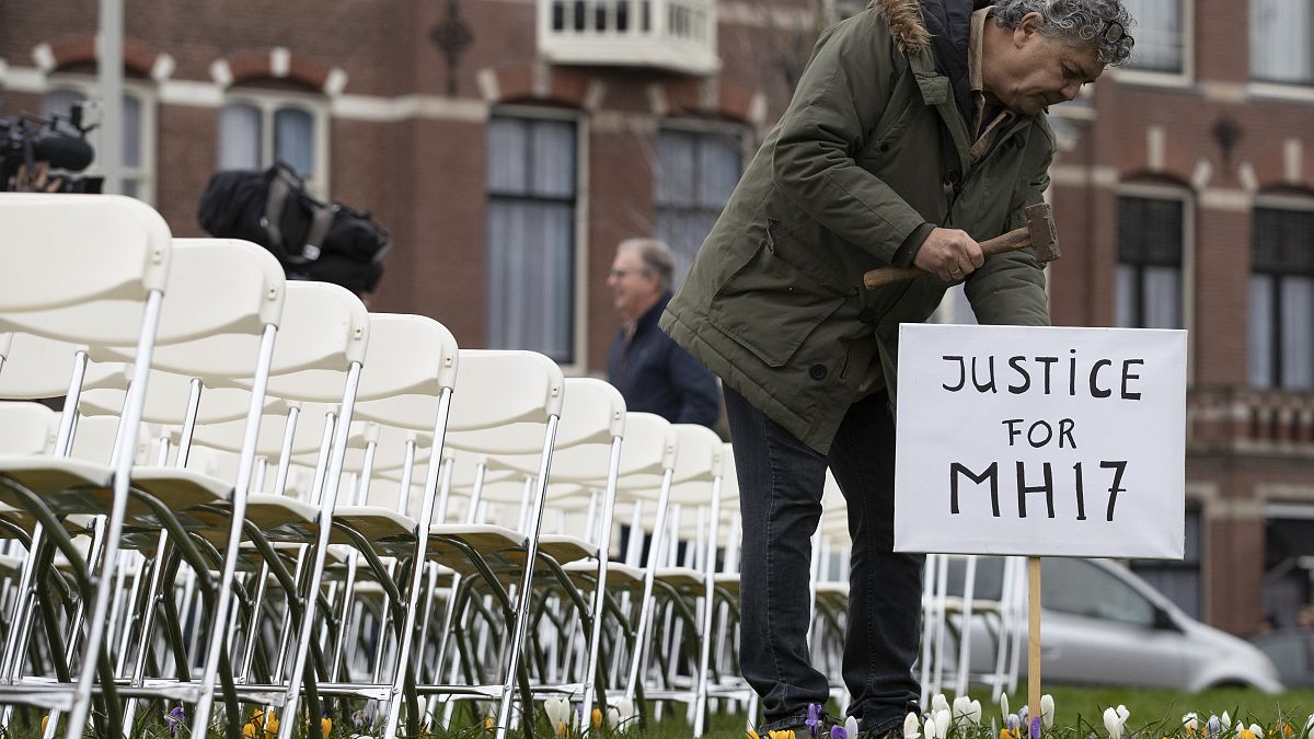 Rob Fredriksz, who lost his son Bryce and his girlfriend Daisy, places a sign next to 298 empty chairs, each chair for one of the 298 victims of the downed MH17.