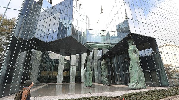 In this Monday, Oct. 22, 2018 file photo, a man stands in front of Poland's Supreme Court building in Warsaw, Poland. In this Monday, Oct. 22, 2018 file photo, a man stands in front of Poland's Supreme Court building in Warsaw, Poland.
