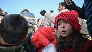 Migrant children wait with adults to receive food near Edirne, northwestern Turkey as they wait to cross the Meritsa river by boat and enter neighbouring Greece