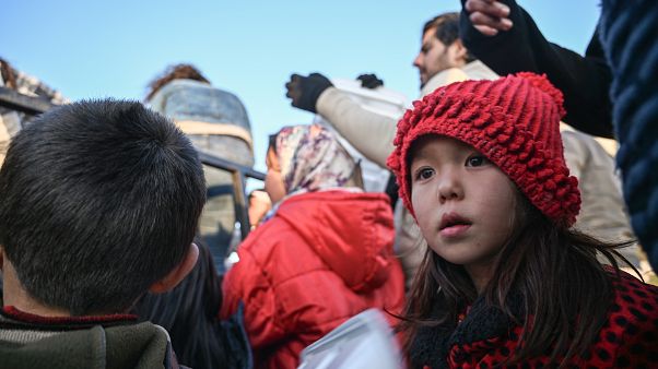 Migrant children wait with adults to receive food near Edirne, northwestern Turkey as they wait to cross the Meritsa river by boat and enter neighbouring Greece Migrant children wait with adults to receive food near Edirne, northwestern Turkey as they wait to cross the Meritsa river by boat and enter neighbouring Greece