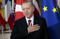 Turkish President Recep Tayyip Erdogan puts his hand over his heart in a gesture of hello prior to a meeting with European Council President Charles Michel.