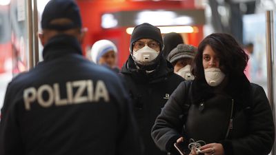 Polizist überprüft Passagiere am Bahnhof in Mailand