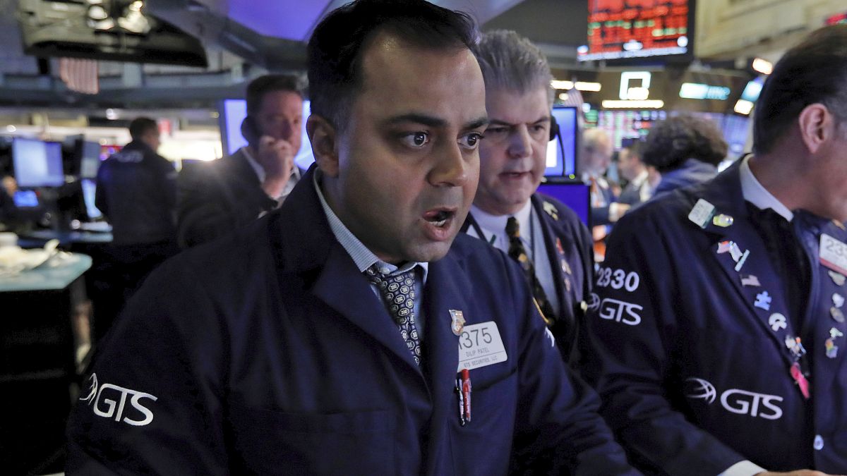 Specialist Dilip Patel, left, works at his post on the floor of the New York Stock Exchange, Monday, March 9, 2020